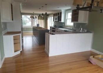 Kitchen cabinets being refinished in a modern home.