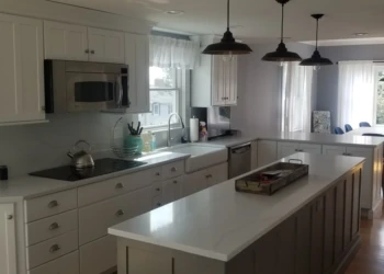 Kitchen cabinets being refinished in a modern, bright kitchen.