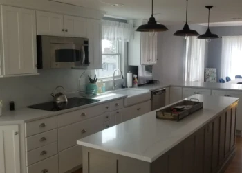 Kitchen cabinets being refinished in a modern, bright kitchen.