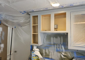 The transformation is becoming visible. With the cabinet boxes painted and the workspace fully contained, homeowners can begin to see why Finish Masters is trusted to deliver results that go far beyond an ordinary cabinet painting project. Finish Masters cabinet painting project in Burlington Massachusetts showing cabinet boxes painted in Benjamin Moore AF-70 Storm with professional dust containment and masking systems in place during the finishing process.