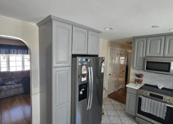 The details make the difference. From the refrigerator enclosure to the crown molding and end panels, every surface was professionally painted in Benjamin Moore AF-70 Storm to create a seamless, furniture-grade appearance throughout the kitchen. Finish Masters cabinet painting project in Burlington Massachusetts showing completed refrigerator surround cabinets painted Benjamin Moore AF-70 Storm with a furniture-grade finish backed by our reputation and written warranty.