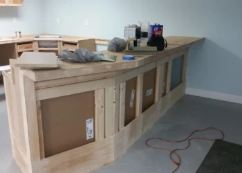 Unfinished wooden kitchen cabinet frames in a basement kitchen under construction in Billerica MA