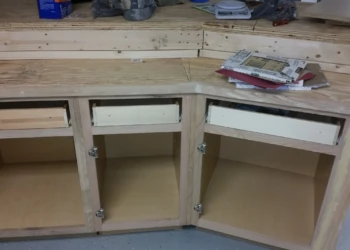 Unfinished oak basement kitchen cabinets with drawers and open door frames in Billerica MA project