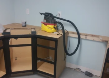 Unfinished black painted oak cabinets fitted in a basement kitchen under construction in Billerica MA with ventilation equipment on countertop