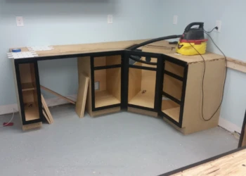 Partially installed black painted oak cabinets in basement kitchen under construction in Billerica MA