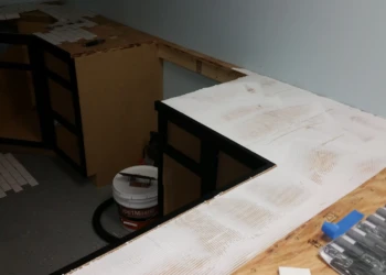 Black painted oak cabinets without countertops installed in a basement kitchen under renovation