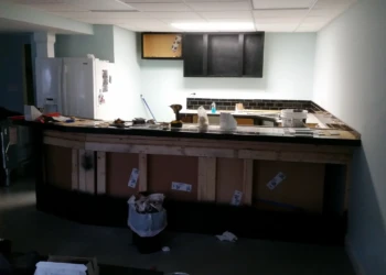 Basement kitchen area showing black painted oak cabinets and a countertop under construction in Billerica MA