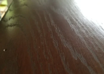 Close-up of bathroom vanity cabinet surface with custom brown stain and high gloss finish in Billerica MA