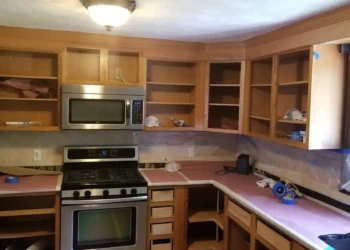 Sanded wooden kitchen cabinets stripped of doors and drawers in preparation for painting in Billerica MA kitchen