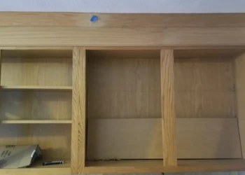 Empty oak wood kitchen wall cabinets without doors or finish in a home in Billerica