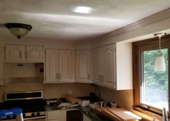 Off-white painted kitchen cabinets with classic raised panel doors in a Billerica home kitchen near a window