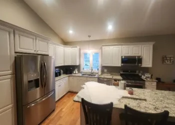 White painted kitchen cabinets with granite countertops and stainless steel appliances in a North Andover, MA home