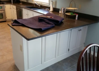 White painted kitchen island cabinets with dark granite countertop in North Andover kitchen