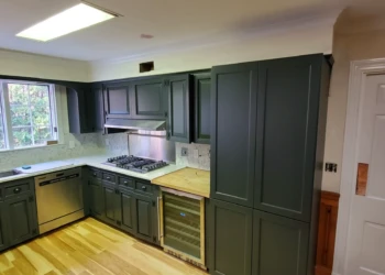 Dark gray painted kitchen cabinets with stainless steel dishwasher and built-in wine fridge in a Bedford NH kitchen