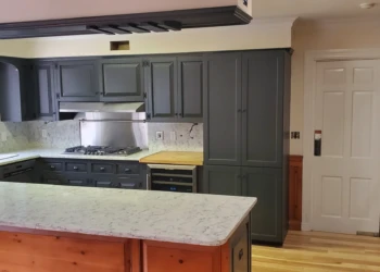 Newly painted dark gray kitchen cabinets with white marble countertops and wooden flooring in Bedford NH kitchen renovation