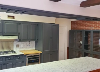 Dark gray painted kitchen cabinets and large kitchen island with marble-style countertop in Bedford NH kitchen