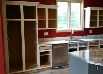 Unfinished kitchen cabinets and island with granite countertops in a Carlisle MA home kitchen