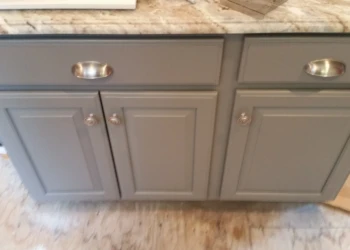 Close-up of grey refinished kitchen cabinets with silver cup and round handles in Carlisle MA kitchen