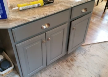 Gray refinished kitchen cabinets with silver hardware and a polished marble countertop in Carlisle MA kitchen