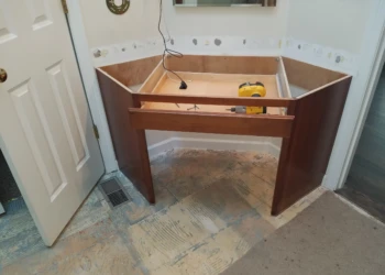 Wooden base cabinet frame with a partially installed drawer front in a Carlisle kitchen under renovation