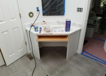Installed corner vanity with white marble countertop and an open wooden drawer in master bathroom Carlisle MA