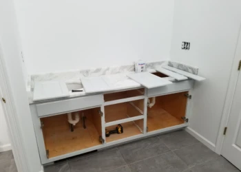 White kitchen base cabinets without doors and drawers with marble countertop in Carlisle MA
