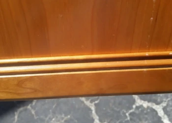 Close-up of a refinished wooden cabinet door in Concord MA, showing smooth, polished surface and new.