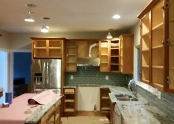 Kitchen cabinets being refinished in Concord MA, showing sanding and preparation for painting.