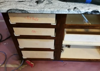 Cabinet refinishing in progress with sanding and masking.