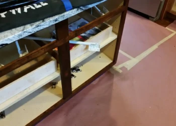 Refinishing cabinets with sanding and masking in a home kitchen.