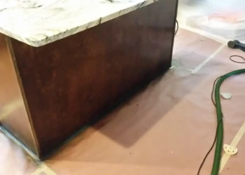 Kitchen cabinet being refinished with a dark stain in progress.