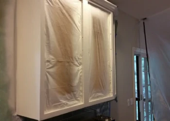 Cabinet refinishing in progress with masking and sanding techniques.