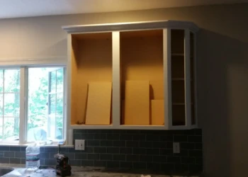 Refinishing cabinets with sanding and painting process shown.