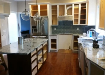 Kitchen cabinets being refinished in Concord MA, with new paint and hardware installation visible.