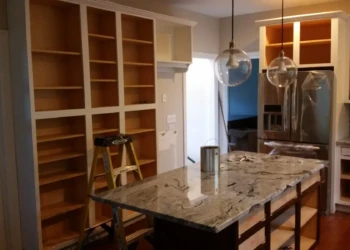 Kitchen cabinets being refinished in Concord MA, with sanding and preparation visible for a smooth,.