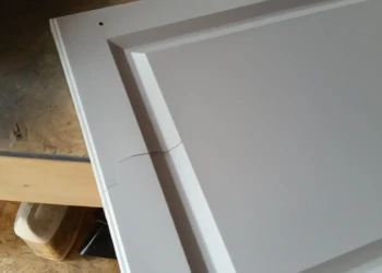 Close-up of a cabinet door being refinished in Concord, MA, showing detailed sanding and preparation.