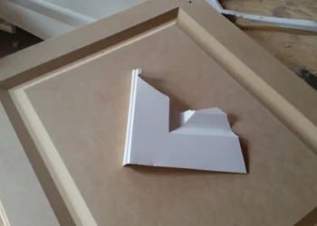 Close-up of a cabinet door being sanded and prepped for refinishing in Concord, MA.