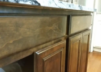 Refinished wooden kitchen cabinets in Concord MA showing smooth, polished surfaces and detailed trim.