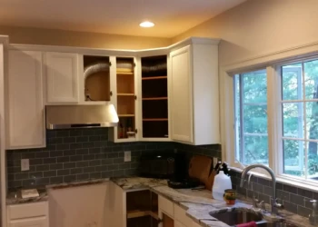 Refinished kitchen cabinets in Concord MA, showing a fresh white paint job and new hardware.