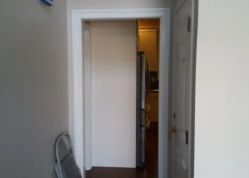 Interior doorway being painted with a roller brush in a home.