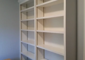 Empty white built-in bookshelves in a room for cabinet refinishing in Concord MA.