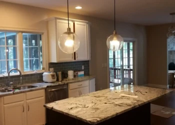 Kitchen cabinets being refinished with a marble countertop in the image.