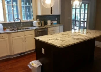 Kitchen cabinets being refinished in Concord MA, with a focus on the freshly painted cabinet doors.