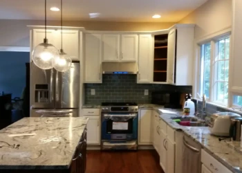 Refinished kitchen cabinets in Concord MA, showing a smooth, glossy white finish and modern hardware.