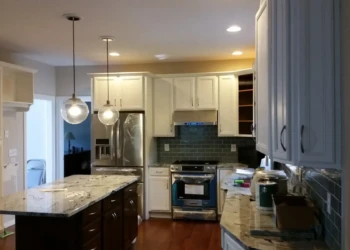 Kitchen cabinets being refinished in Concord MA, showing a mix of painted and stained cabinetry with.