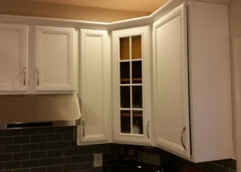 Kitchen cabinets being refinished in Concord MA, with fresh white paint and new hardware.