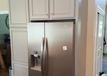 Grey kitchen cabinets refinished around stainless steel Samsung refrigerator in a Groton MA kitchen