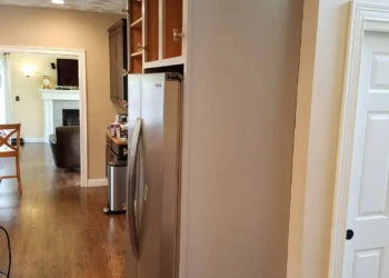 Kitchen cabinets in a home in Groton MA mid-refinishing with cabinet doors removed showing wood frames