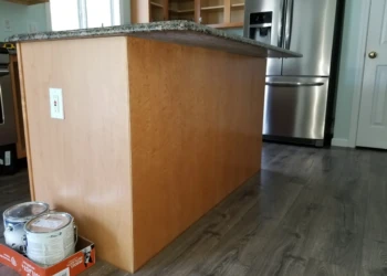 Wooden kitchen island base with fresh cabinet refinishing and granite countertop in a Merrimack NH kitchen