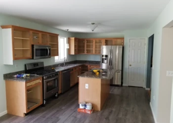 Partially refinished kitchen cabinets with open doors and new decorative bead board on island in Merrimack, NH kitchen